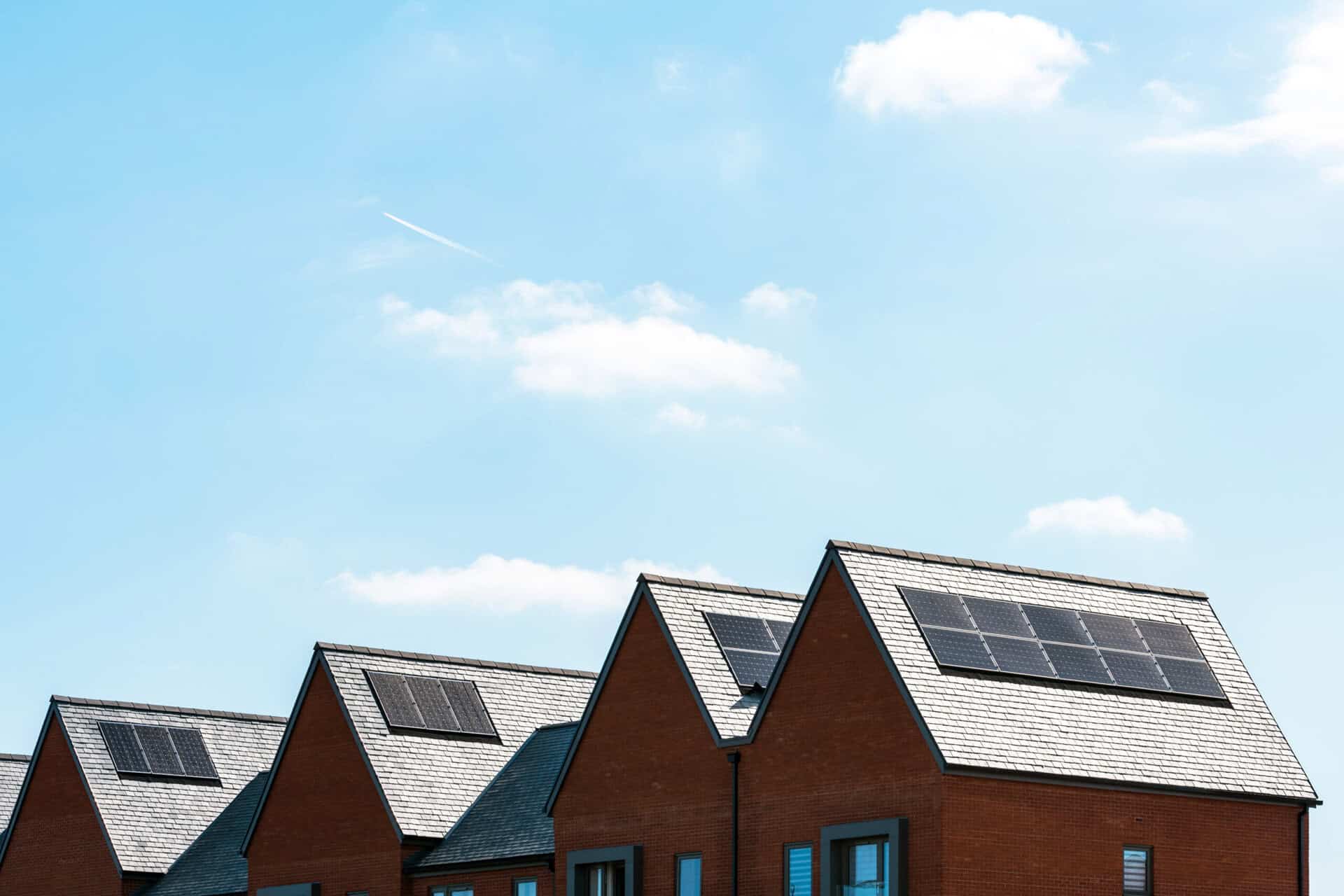 solar panels on roof of new houses in england uk on bright sunny day.